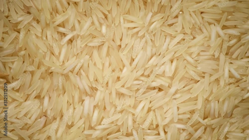 White raw organic basmati rice rotation background. Food ingredient background. Top view, healthy lifestyle concept. White raw organic basmati rice rotation background. Food ingredient background. Top view, healthy lifestyle concept.