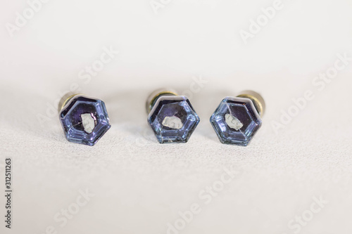 front of three very small blue glass drawer knobs or pulls