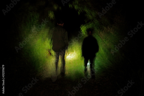 Night jungle walk in the tropic forest. Two man in the dark night, Corcovadon NP, Costa Rica. Light in the tropic green vegetation. © ondrejprosicky