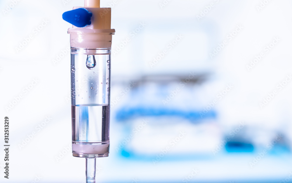 Dripping medical perfusion close up equipment in clinic background. Saline Solution IV Drip Fluid for Infusion in Hospital. Intravenous infusion tube equipment in hospital. Health patient concept. Dripping medical perfusion close up equipment in clinic background. Saline Solution IV Drip Fluid for Infusion in Hospital. Intravenous infusion tube equipment in hospital. Health patient concept.