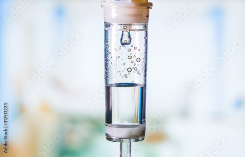 Dripping medical perfusion close up equipment in clinic background. Saline Solution IV Drip Fluid for Infusion in Hospital. Intravenous infusion tube equipment in hospital. Health patient concept.