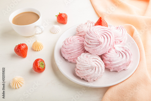 Pink strawberry homemade zephyr or marshmallow with cup of coffee on white wooden background. side view.