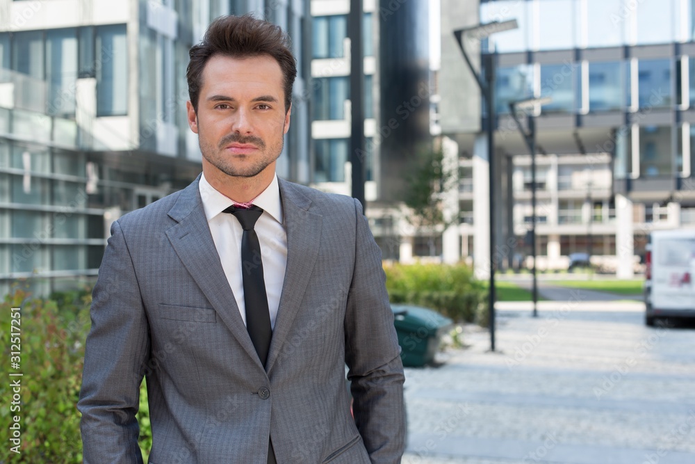 Portrait of confident young businessman standing outside office building Portrait of confident young businessman standing outside office building