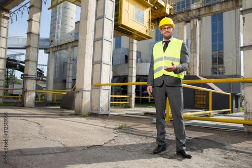 Full length portrait of confident male engineer gesturing outside industry © moodboard