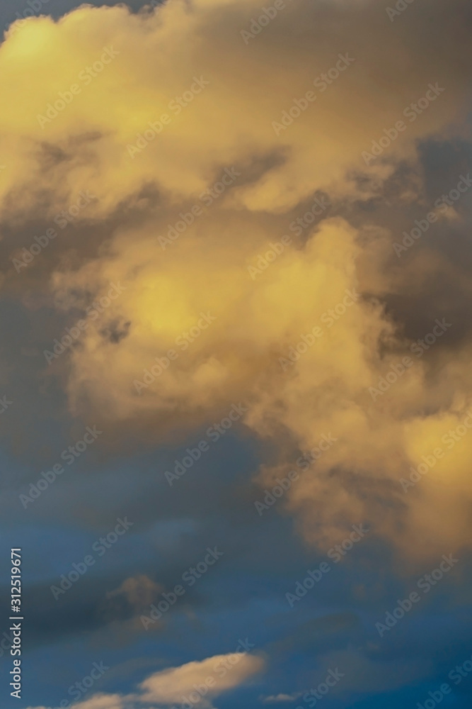evening blue sky with beautiful sun-bathed clouds as natural background