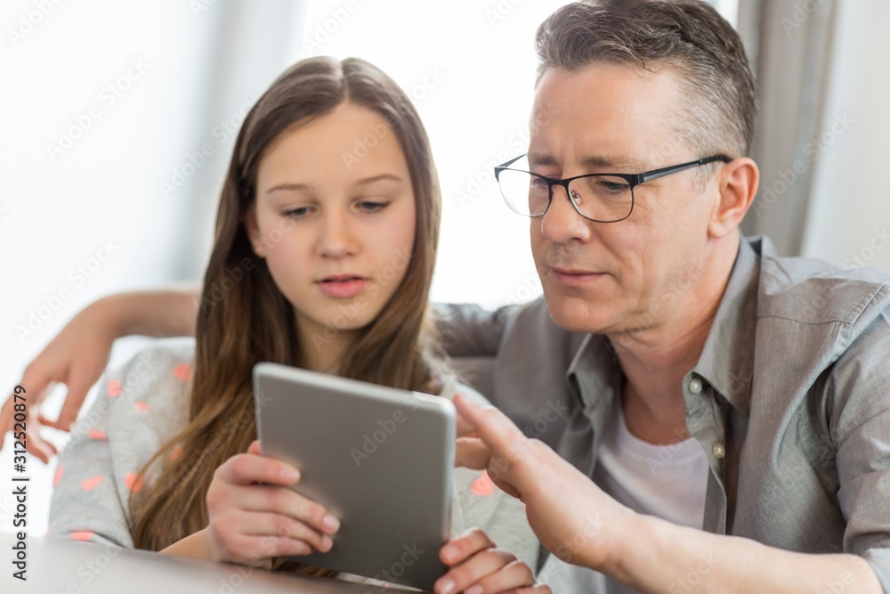 Father and daughter using digital tablet at home Father and daughter using digital tablet at home