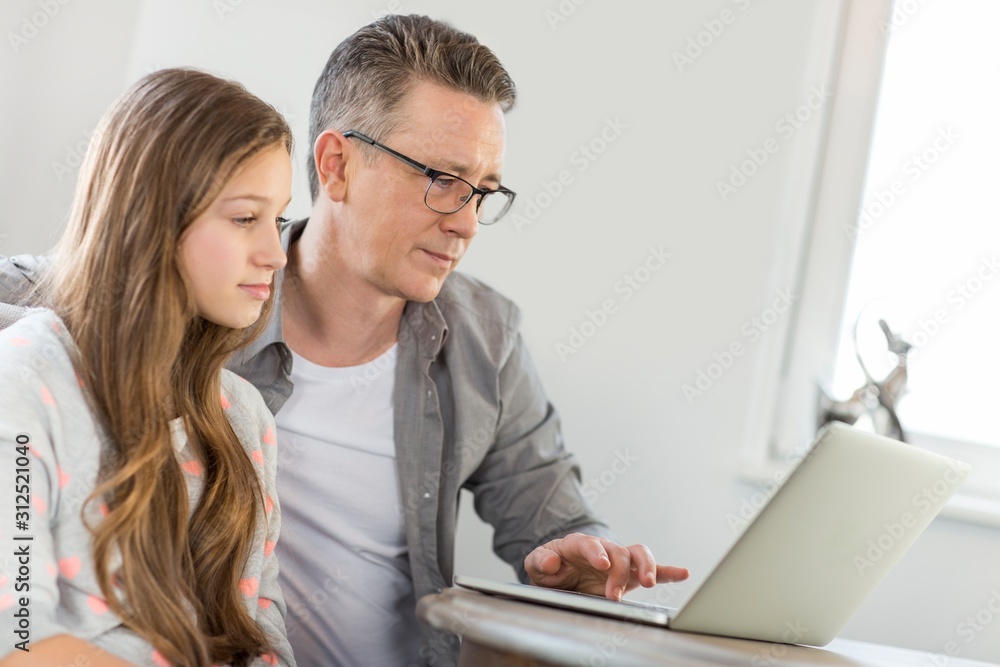Father and daughter using laptop at home Father and daughter using laptop at home