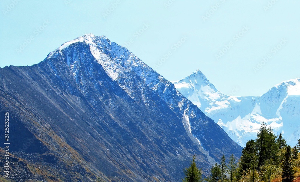 snowy mountain peaks against the sky and a mountain plateau from a height