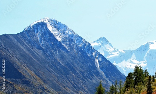snowy mountain peaks against the sky and a mountain plateau from a height