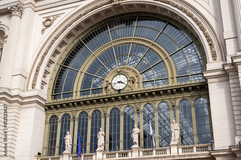 Old city railway station exterior detail. Glass detail on facade with clock