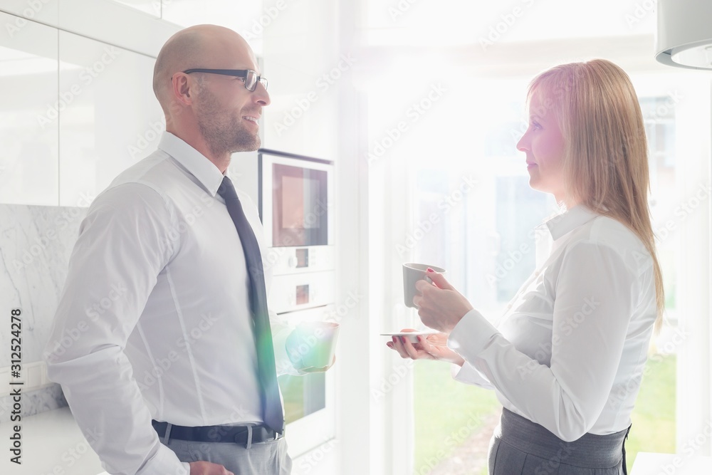 Side view of mid adult business couple talking at home Side view of mid adult business couple talking at home