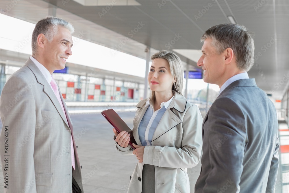 Businessman communicating with colleagues on train platform