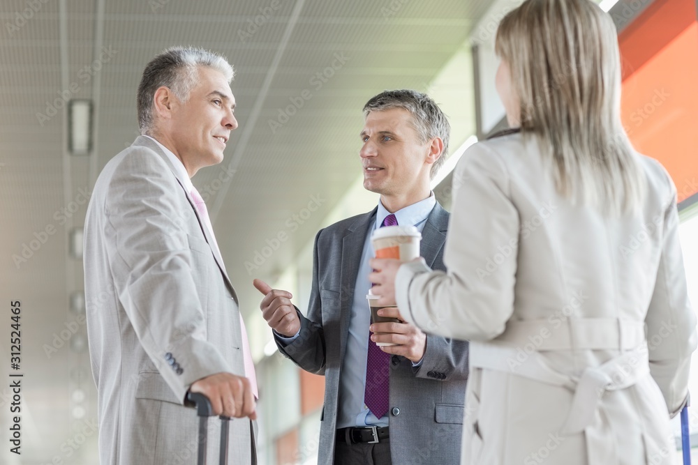 Businesspeople communicating on railroad platform Businesspeople communicating on railroad platform