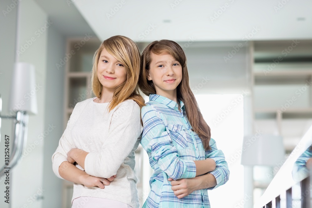 Portrait of cute sisters standing together at home Portrait of cute sisters standing together at home