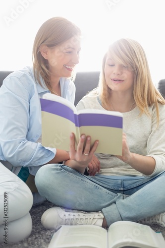 Mother assisting daughter in homework at home