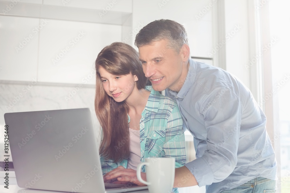 Father and daughter using laptop at home Father and daughter using laptop at home