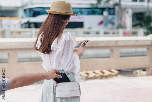 Foto Stealing wallet from the pickpocket from shoulder bag of tourist girl
