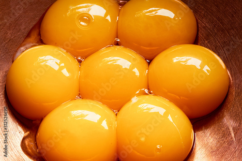 Cuadro en lienzo Seven egg yolks in capper bowl , close up, top view, close up