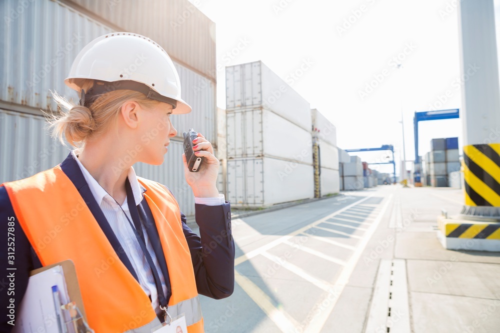 Female engineer using walkie-talkie in shipping yard Female engineer using walkie-talkie in shipping yard