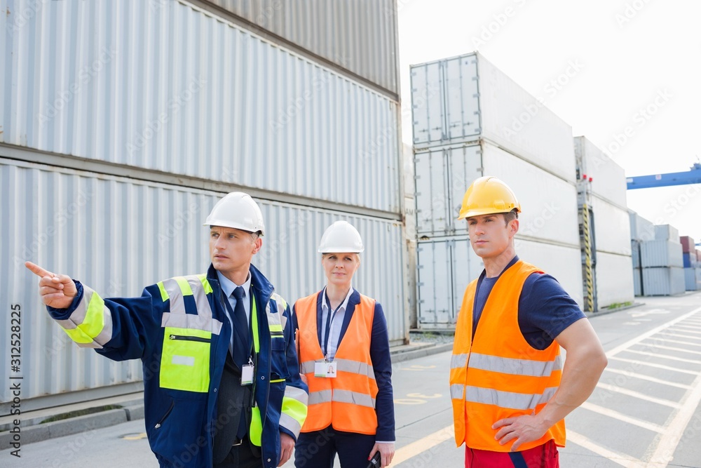 Workers discussing in shipping yard Workers discussing in shipping yard