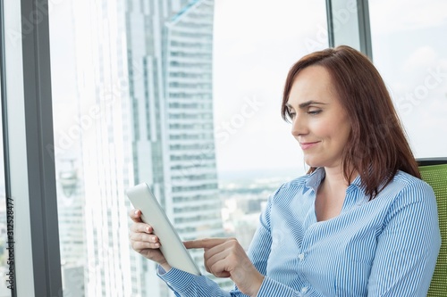 Mid-adult businesswoman using digital tablet in office Free Download Mid-adult businesswoman using digital tablet in office - GFXLoad