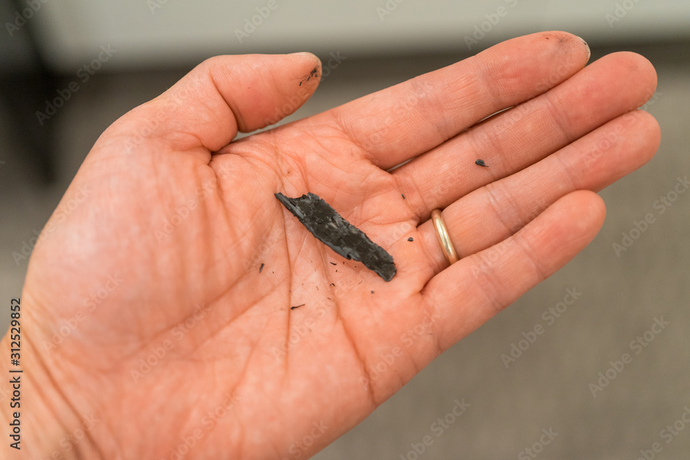 Fire ash ember dropped from the air into a human hand palm