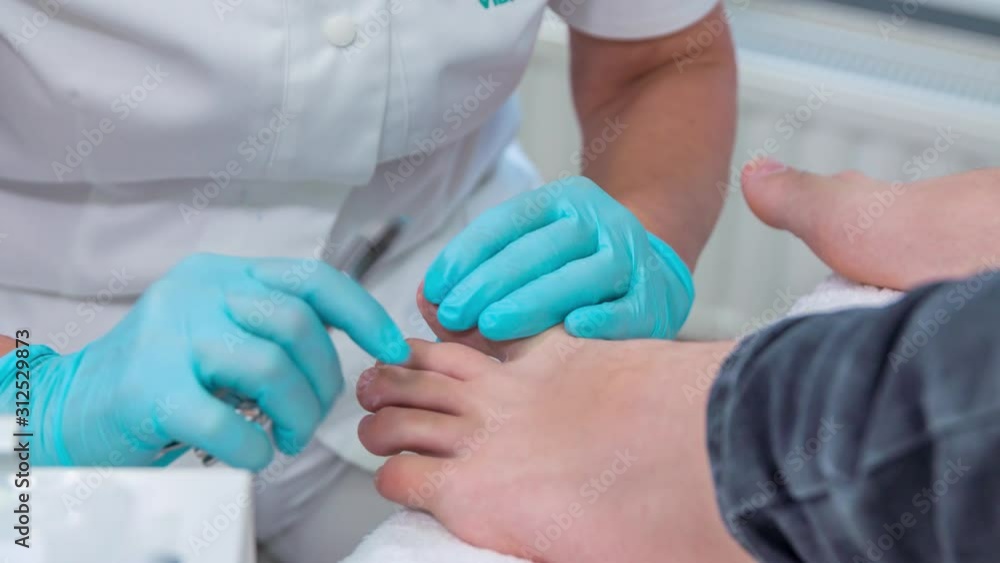 Beautician is cutting her client's nails on her feet and is doing a whole massage and pedicure of her feet in a massage studio. Beautician is cutting her client's nails on her feet and is doing a whole massage and pedicure of her feet in a massage studio.
