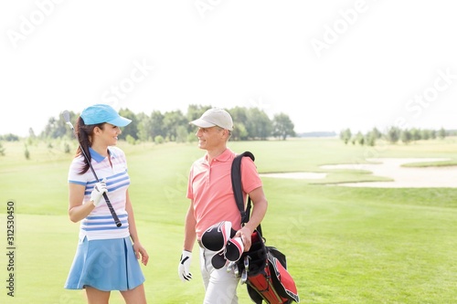 Male and female golfers communicating at golf course