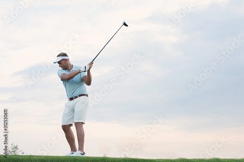 Mid-adult man playing golf against sky
