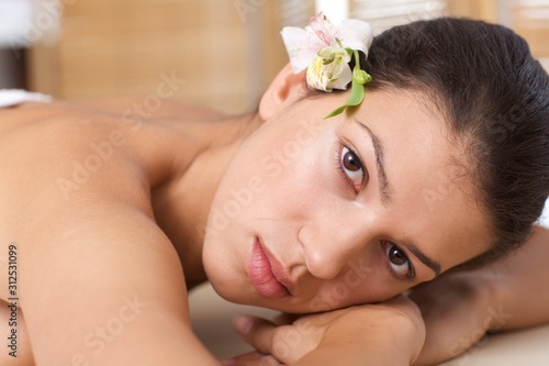 Close-up of young woman relaxing on massage table