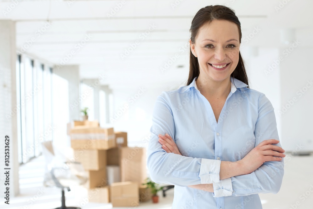 Portrait of smiling mid adult businesswoman standing arms crossed in new office Portrait of smiling mid adult businesswoman standing arms crossed in new office