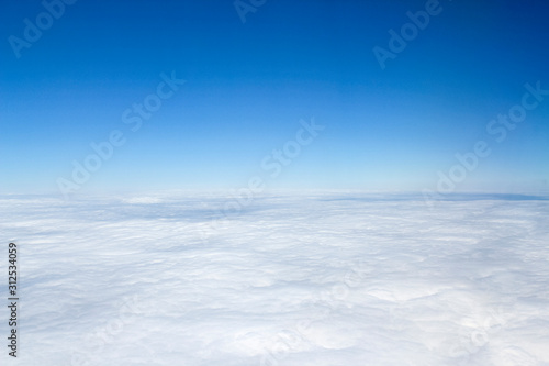 Aerial view above the clouds with blue sky
