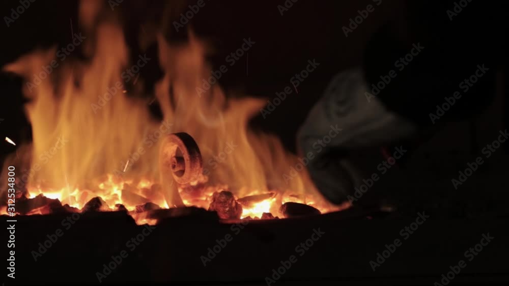 Metalworker forged hot piece of metal, closeup Metalworker forged hot piece of metal, closeup