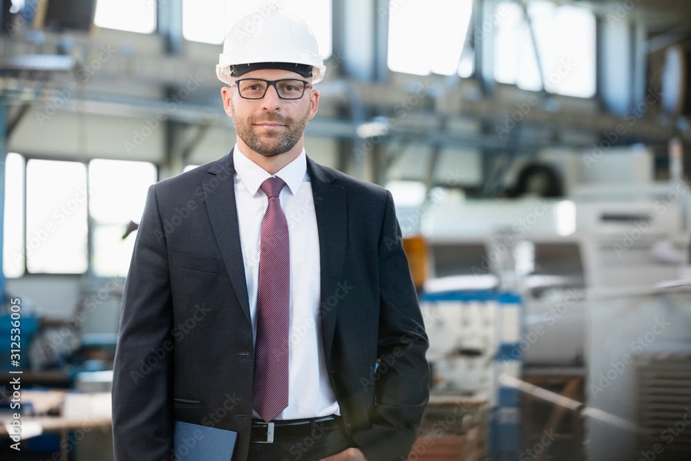 Portrait of confident mid adult businessman wearing hardhat in metal industry Portrait of confident mid adult businessman wearing hardhat in metal industry