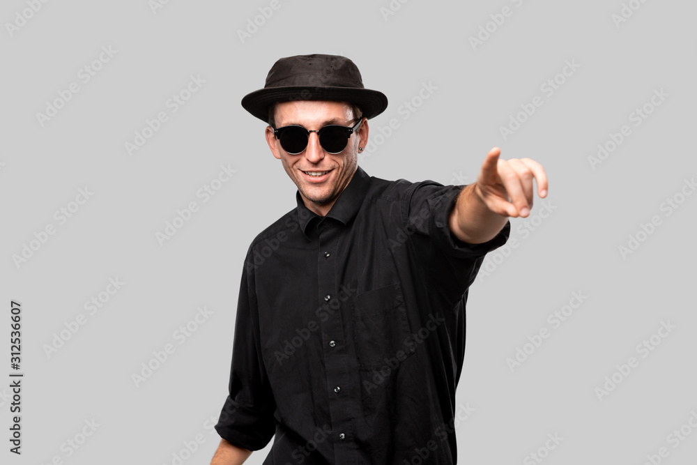 Stylish handsome man a black shirt and pork pie hat isolated over grey background Stylish handsome man a black shirt and pork pie hat isolated over grey background