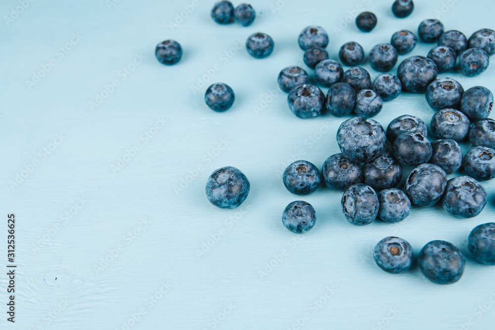 Ripe blueberries on a blue wooden background copy space. Harvest blueberries. Blue berry background. Ripe blueberries on a blue wooden background copy space. Harvest blueberries. Blue berry background.