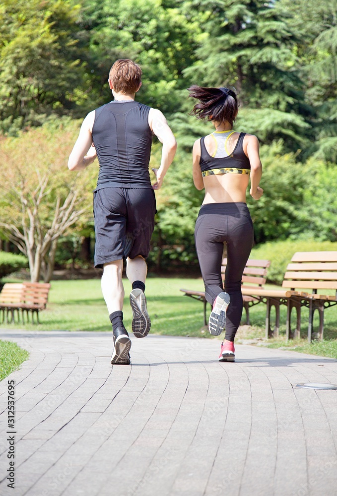 Fototapeta premium Young couple running in the park