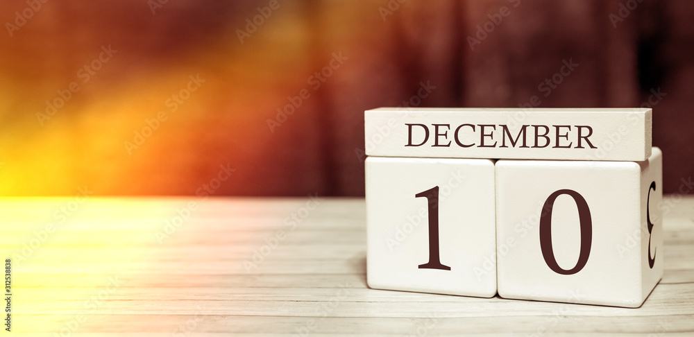 Calendar reminder event concept. Wooden cubes with numbers and month on December 10 with sunlight. Calendar reminder event concept. Wooden cubes with numbers and month on December 10 with sunlight.
