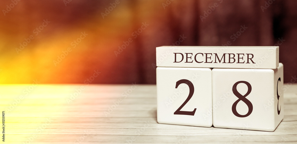 Calendar reminder event concept. Wooden cubes with numbers and month on December 28 with sunlight. Calendar reminder event concept. Wooden cubes with numbers and month on December 28 with sunlight.