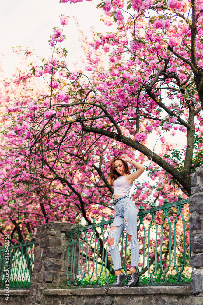 fashion model posing near pink spring tree fashion model posing near pink spring tree