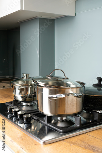 Modern stainless steel gas stove oven in a home with various cookware