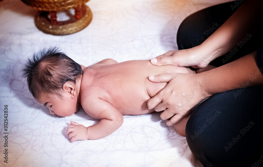 The newborn baby was massaging by Therapist hands,for stimulate development program,blurry light around