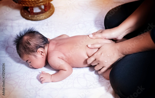 The newborn baby was massaging by Therapist hands,for stimulate development program,blurry light around