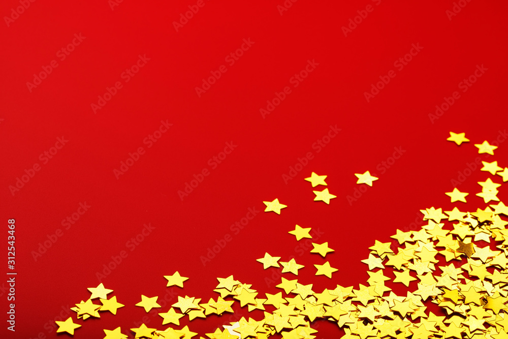 Gold stars on red background. The concept of greeting cards, headlines and web site. A scattering of Golden stars