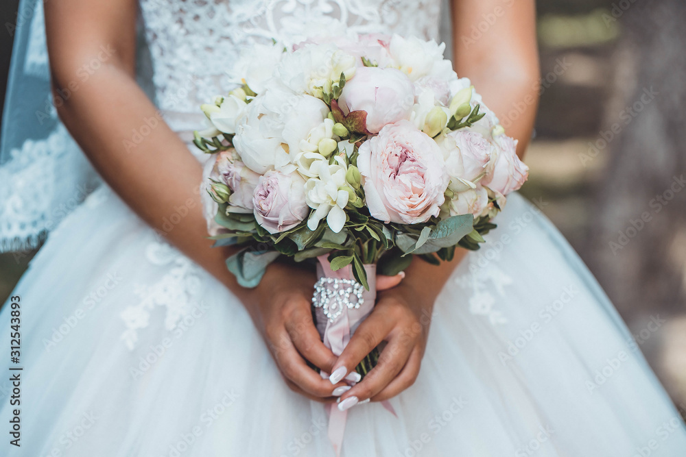 Beautiful wedding bouquet in bride's hand. peonies