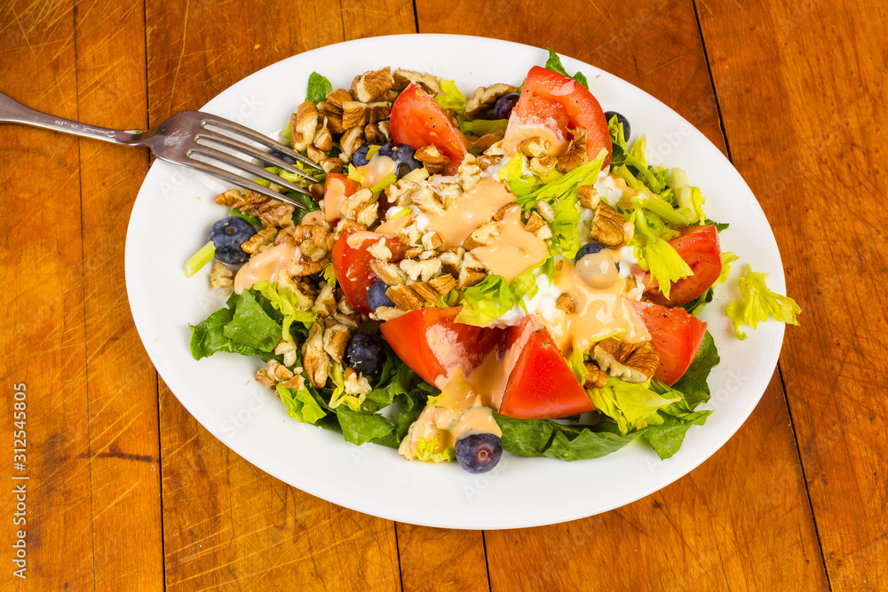 Large Mixed Salad with Thousand Island Dressing on Rustic Wooden Picnic Table Large Mixed Salad with Thousand Island Dressing on Rustic Wooden Picnic Table