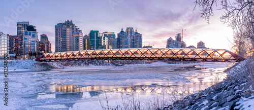 Evening skyline view along the Bow River in Calgary, Alberta. Peace Bridge visible. 