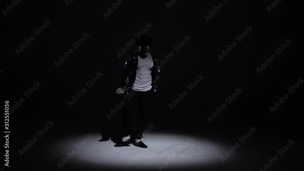 Young stylish man dancing, spotlight on a black background. Young stylish man dancing, spotlight on a black background.