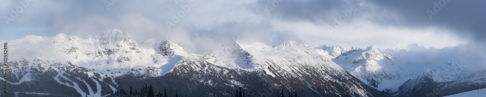 Whistler, British Columbia, Canada. Beautiful View of the Canadian Snow Covered Landscape with Blackcomb Mountain in Background during a cloudy and foggy winter day.
