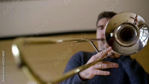 trombonist playing music, blowing air and moving tube photo